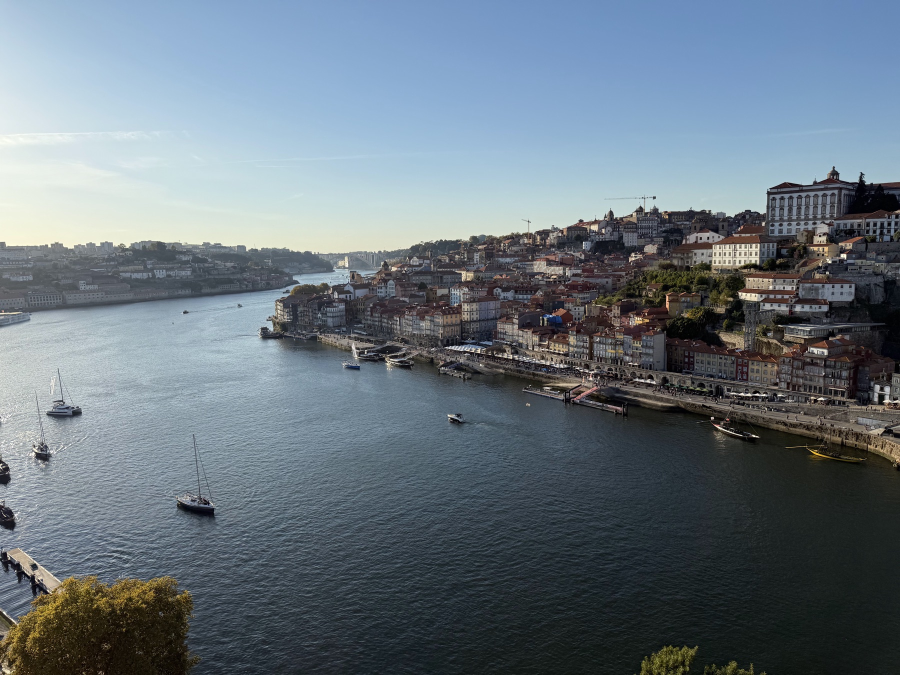 Blick über den Douro auf die Altstadt von Porto mit Booten auf dem Fluss.
